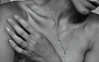 Woman wearing a delicate diamond cross necklace and ring, elegant fine jewelry for women – Diamond Crosses for Women.
